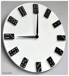 a white clock with black dominos on it