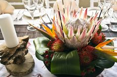 the table is set with an arrangement of flowers, candles and napkins on it