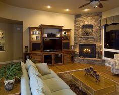 a living room filled with furniture and a flat screen tv mounted on a wall next to a fire place