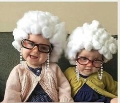 two children wearing wigs and glasses sitting next to each other