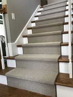 a set of stairs with carpet on the bottom and top, in a house or office