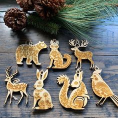 several wooden animals are sitting next to pine cones