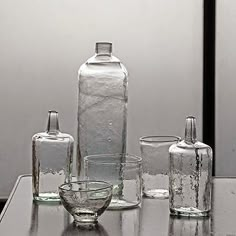 several glass bottles and glasses sitting on a table