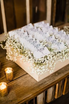 a table topped with lots of white flowers and candles