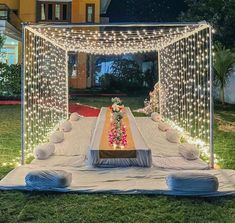 an outdoor wedding setup with lights and flowers