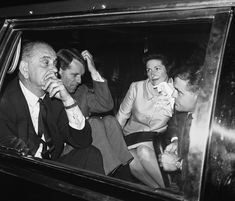 an old black and white photo of three people in a car with one man holding his mouth open