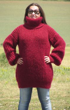 a woman in a red sweater is posing for the camera with her hands on her head