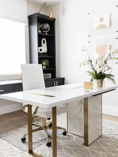 a white desk in an office with gold legs and a black bookcase behind it