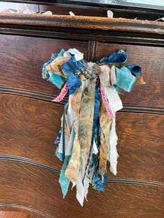 an old dresser has been decorated with fabric and ribbons on the top, along with other things