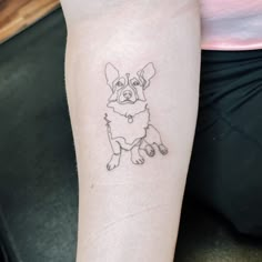 a small dog tattoo on the left arm