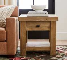 a wooden table with a bowl on top of it in front of a brown couch