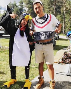 a man and woman dressed up in costumes posing for a photo with a penguin costume on