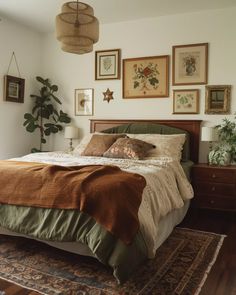 a bed sitting on top of a wooden floor next to a wall filled with pictures