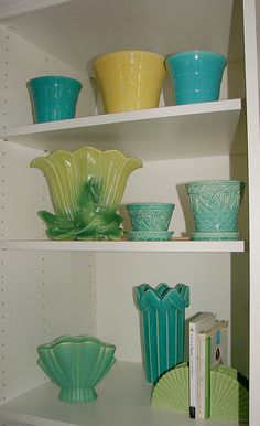 the shelves are filled with colorful glass bowls and vases