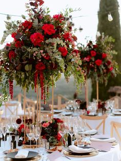 the centerpieces are adorned with red flowers and greenery