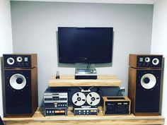 an entertainment center with stereo, speakers and a flat screen tv on top of it