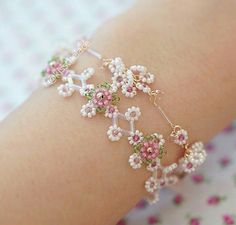 a close up of a person's arm wearing a bracelet with flowers on it