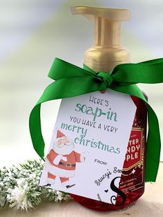 a bottle of soap sitting on top of a wooden table next to a green ribbon