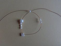 two white beads are connected to a wire