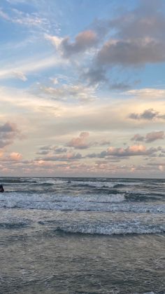 two surfers walking into the ocean with their surfboards