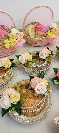 baskets filled with flowers and cookies on top of a table next to other food items