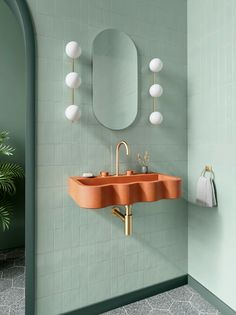 an orange sink in a bathroom next to a mirror