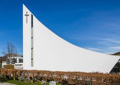 a large white building with a cross on it's side next to a cemetery