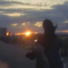 a blurry image of the sun setting behind a person