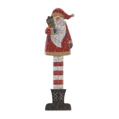 a wooden santa clause standing on top of a pole