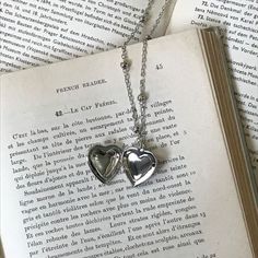 two heart shaped lockes on top of an open book