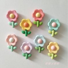 there are many small plastic flowers in the shape of magnets that look like they have been made from polymer