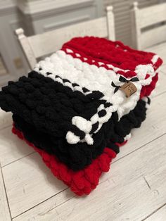 three pieces of crocheted blanket sitting on top of a white table next to each other