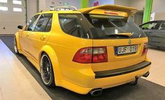 the rear end of a yellow car parked in a garage