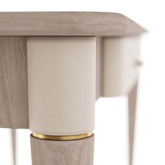 the back end of a white table with gold trimmings and a wooden top