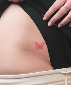 a woman's stomach with a butterfly tattoo on the side and her left arm