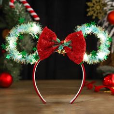 a mickey mouse ears headband decorated with christmas lights and bows for the holiday season