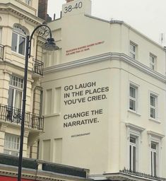 an advertisement on the side of a building in front of a street light and traffic lights