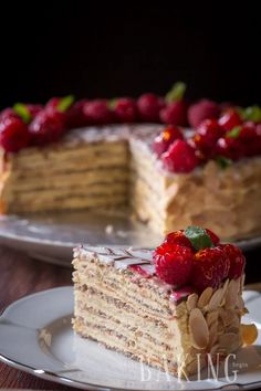 a piece of cake with strawberries on top is sitting on a plate next to the rest of the cake