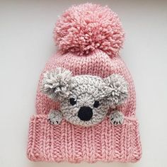 a pink knitted hat with a koala bear on it's front and sides