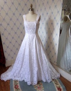 a white wedding dress on display in front of a mirror