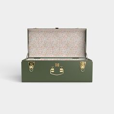 a green suitcase with gold handles and floral print linings on the lid, open