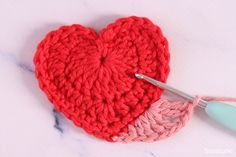 a crocheted heart with a knitting needle next to it