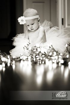 a baby is sitting on the floor in front of candles