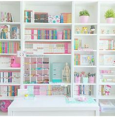 a room filled with lots of white shelves and colorful books on top of it's walls