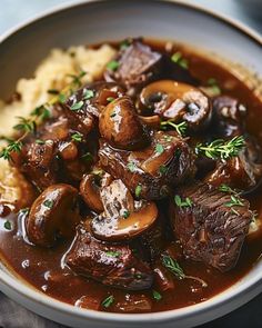 a white bowl filled with mushrooms and mashed potatoes