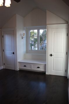 an empty room with white doors and windows