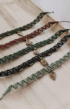 five different bracelets with charms on them sitting on a table next to each other