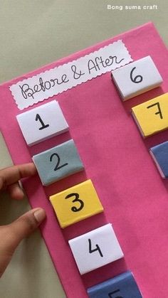 someone is placing numbers on a pink piece of paper