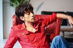 a young man sitting in a red chair