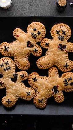 several small pies are arranged in the shape of teddy bears on a black surface